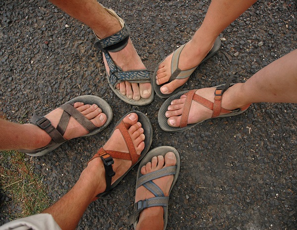 A group of friends show off their dirty feet after a weekend of camping.